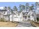 White farmhouse style home with large windows and a three car garage at 366 Davis Love Dr, Chapel Hill, NC 27517