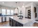 Modern kitchen island with dark lower cabinets and expansive countertop at 1212 Holding Village Way, Wake Forest, NC 27587