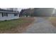 Gravel driveway leading to a single-story home at 332 Bass Lake Road Rd, Holly Springs, NC 27540