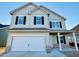 Two-story home with light beige siding, brick accents, and a two-car garage at 83 Meath Ct # 209, Clayton, NC 27520