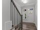 Bright entryway with hardwood floors and staircase with black metal railing at 507 Excelsior Ct, Rolesville, NC 27587