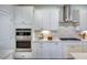 White kitchen with stainless steel appliances and herringbone backsplash at 166 Blue Butterfly Dr, Angier, NC 27501