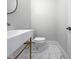 Small bathroom with toilet and sink, featuring marble-style tile floors at 4700 Linaria Ln, Fuquay Varina, NC 27526