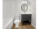 Bathroom with dark vanity, oval mirror, and tile floor at 4700 Linaria Ln, Fuquay Varina, NC 27526