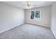 Bright bedroom featuring a large window and plush gray carpeting at 4700 Linaria Ln, Fuquay Varina, NC 27526
