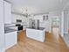 Modern kitchen with white cabinets, granite island, and hardwood floors at 4700 Linaria Ln, Fuquay Varina, NC 27526