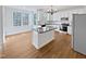 Eat-in kitchen with white cabinets, granite island, and hardwood floors at 4700 Linaria Ln, Fuquay Varina, NC 27526