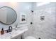 Clean bathroom with marble shower, pedestal sink, and round mirror at 542 E Martin St, Raleigh, NC 27601