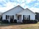 White house with black shutters, landscaping, and a spacious yard at 102 Shadow Bend Ln, Selma, NC 27576