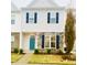 Two-story townhome with gray siding, teal door, and stone accents at 242 Liam St, Clayton, NC 27520