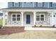 Covered front porch with stone accents and a blue front door at 68 Northwood Dr, Fuquay Varina, NC 27526