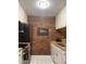 Full kitchen view with stainless steel appliances and brick wall at 807 W Trinity Ave # 209, Durham, NC 27701