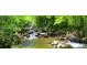 Serene creek flowing through lush greenery, creating a tranquil natural setting at 175 Clear Springs Ct, Pittsboro, NC 27312