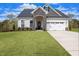 Two-story house with stone accents, two-car garage, and manicured lawn at 72 Macy Circle, Wendell, NC 27591