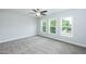 Bedroom with carpeted floors, ceiling fan, and three large windows at 807 E Harnett St, Dunn, NC 28334