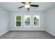 A bedroom with gray carpeting and three large windows offering ample natural light at 807 E Harnett St, Dunn, NC 28334