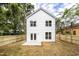 Back exterior of a two-story white house with a fenced backyard and patio at 807 E Harnett St, Dunn, NC 28334