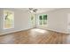 Bright living room with hardwood floors, ceiling fan, and several large windows at 807 E Harnett St, Dunn, NC 28334