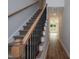 Carpeted staircase with wood handrail and black metal balusters leading to hallway at 807 E Harnett St, Dunn, NC 28334