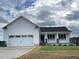 White house with a two-car garage and a nicely landscaped lawn at 130 Tulipfield Way, Benson, NC 27504