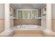 Elegant bathroom with a soaking tub, large windows, and columns at 32520 Archdale Dr, Chapel Hill, NC 27517