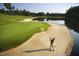 Golfer taking a shot from a sand trap next to a lake at 32520 Archdale Dr, Chapel Hill, NC 27517