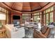 Bright sunroom with vaulted ceiling, fireplace, and ample seating at 32520 Archdale Dr, Chapel Hill, NC 27517