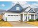 Two-story home with white and blue siding, a two-car garage, and a landscaped yard at 63 Lighthaven Ln, Clayton, NC 27527