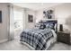 Well-lit bedroom with a plaid comforter and nightstand at 8913 Stratus St, Willow Springs, NC 27592