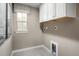 Bright laundry room featuring white cabinets and tile floor at 8913 Stratus St, Willow Springs, NC 27592