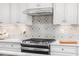 Stainless steel gas range with patterned backsplash at 8913 Stratus St, Willow Springs, NC 27592