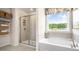 Spa-like bathroom featuring a soaking tub, shower, and large window at 310 Umstead St, Sanford, NC 27330