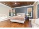 Bright main bedroom with hardwood floors, wood ceiling, and large windows at 3319 Milton Rd, Raleigh, NC 27609