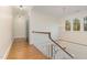 Upstairs hallway with hardwood floors, white railing, and chandelier at 3319 Milton Rd, Raleigh, NC 27609