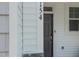 Gray front door with sidelights, nestled in white siding at 402 Thompson Overlook Way, Smithfield, NC 27577