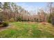 Spacious backyard with a garden, walkway, and lush lawn surrounded by trees at 624 Great Pine Way, Raleigh, NC 27614