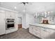 Kitchen with a large island, white cabinets and a view into the living room at 624 Great Pine Way, Raleigh, NC 27614