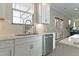 White kitchen with stainless steel appliances, double sink, and access to backyard at 1318 Reading Ct, Burlington, NC 27217