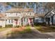 Gray townhome exterior with red door and landscaping at 1402 Mahonia Ct, Raleigh, NC 27615