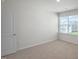 Well-lit bedroom with a door and window at 273 Hanging Elm Ln, Fuquay Varina, NC 27526