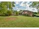 Brick house with a large backyard, partially visible pool, and lush landscaping at 304 Homestead Rd. Rd, Chapel Hill, NC 27516