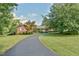 Brick ranch home with long driveway, mature trees, and landscaped yard at 304 Homestead Rd. Rd, Chapel Hill, NC 27516