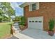 Brick garage with white door, landscaping, and stone steps at 304 Homestead Rd. Rd, Chapel Hill, NC 27516