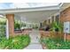 Covered patio with brick flooring, grill, and lush greenery at 304 Homestead Rd. Rd, Chapel Hill, NC 27516