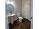 Simple bathroom with pedestal sink, toilet, and dark hardwood floors at 4900 Pioneer Dr, Sanford, NC 27330