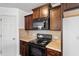 Modern kitchen with dark wood cabinets, granite countertops and built-in microwave at 88 Norris Farm Dr, Angier, NC 27501