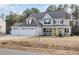 Charming two-story home with a three-car garage, front porch, and yellow front door at 104 Coats Ridge Dr, Benson, NC 27504