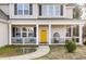 Welcoming front porch with seating, a bright yellow door, and a charming entryway at 104 Coats Ridge Dr, Benson, NC 27504