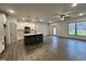 Kitchen and living area with wood-look flooring, ceiling fan, and access to the backyard at 136 S Mistflower St, Clayton, NC 27520