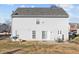 Rear exterior view of two-story gray home with patio, backyard, and trees at 170 Shore Pine Dr, Youngsville, NC 27596